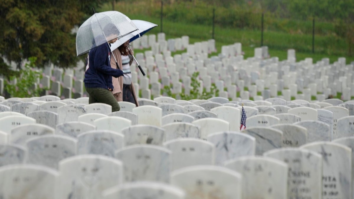 A woman carries an umbrella while at a cemetery on Memorial Day